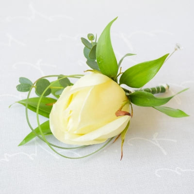 Single Rose Buttonhole - Magnolia the Florist rose buttonhole is the perfect finishing touch to add to your outfit for a special occasion, wedding, christening or funeral. Includes: 1 Large Headed Rose Touch of foliage accent Pin Please Note - Buttonholes are made for the day of the event ONLY and will only last around 6-8 hours from attaching to the outfit due to body heat. This item requires 1 day notice to order.