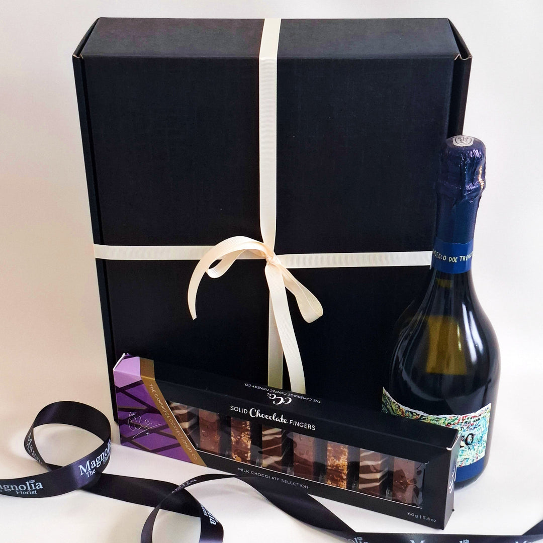 Gift box with a bottle of prosecco and chocolate fingers on a white background