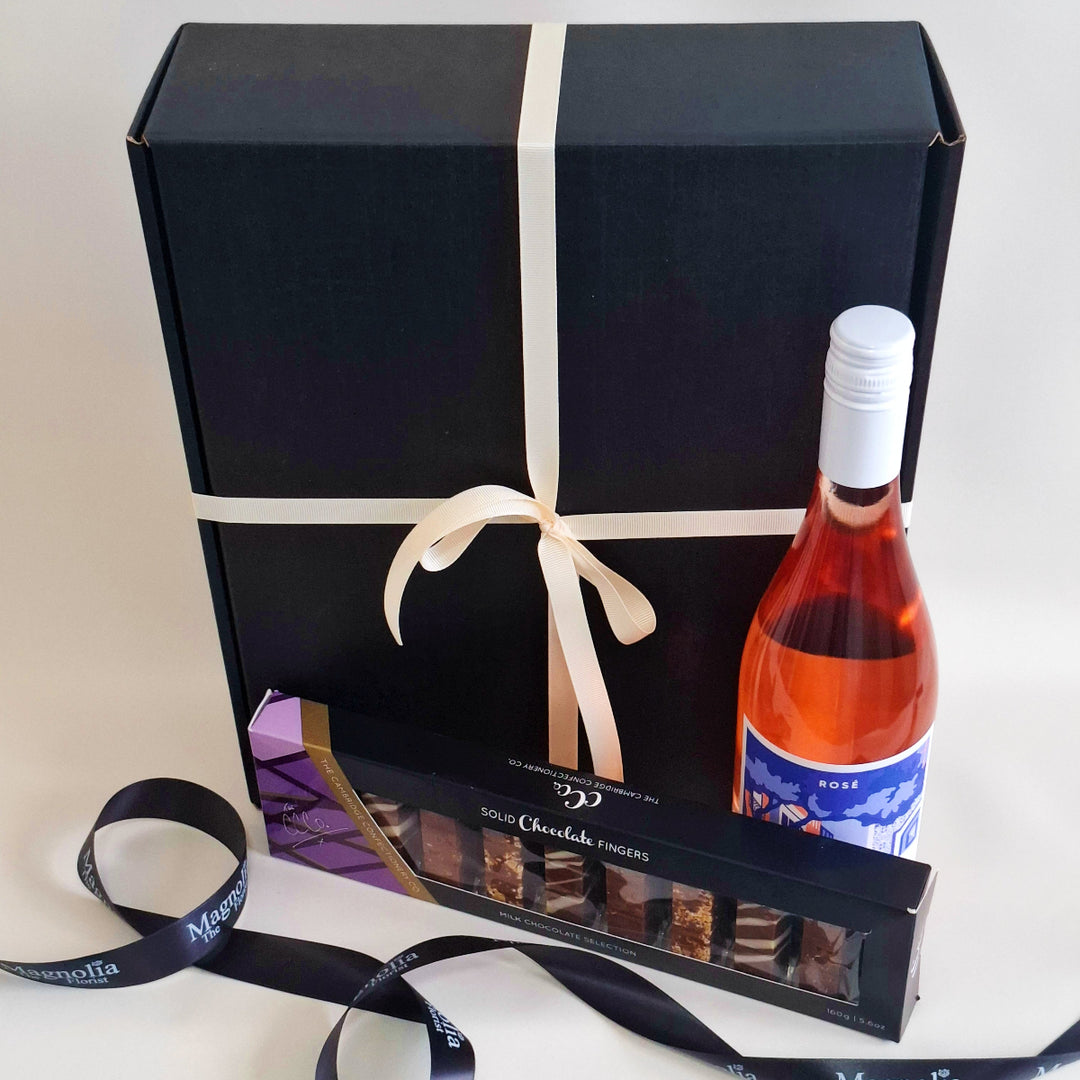 Gift box with a bottle of rosé wine and chocolate truffles on a white background