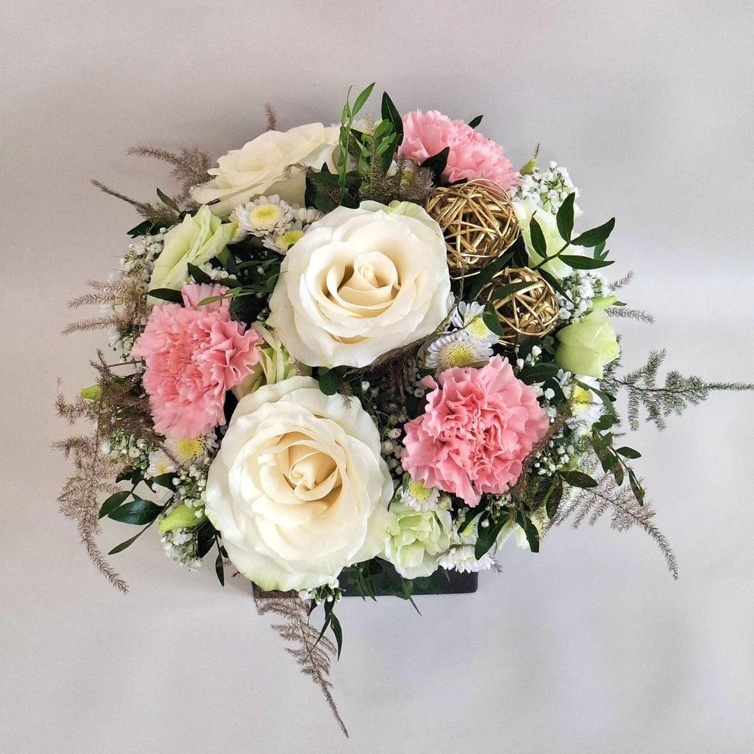 Arrangment of pink and white toned flowers in a Magnolia branded box.