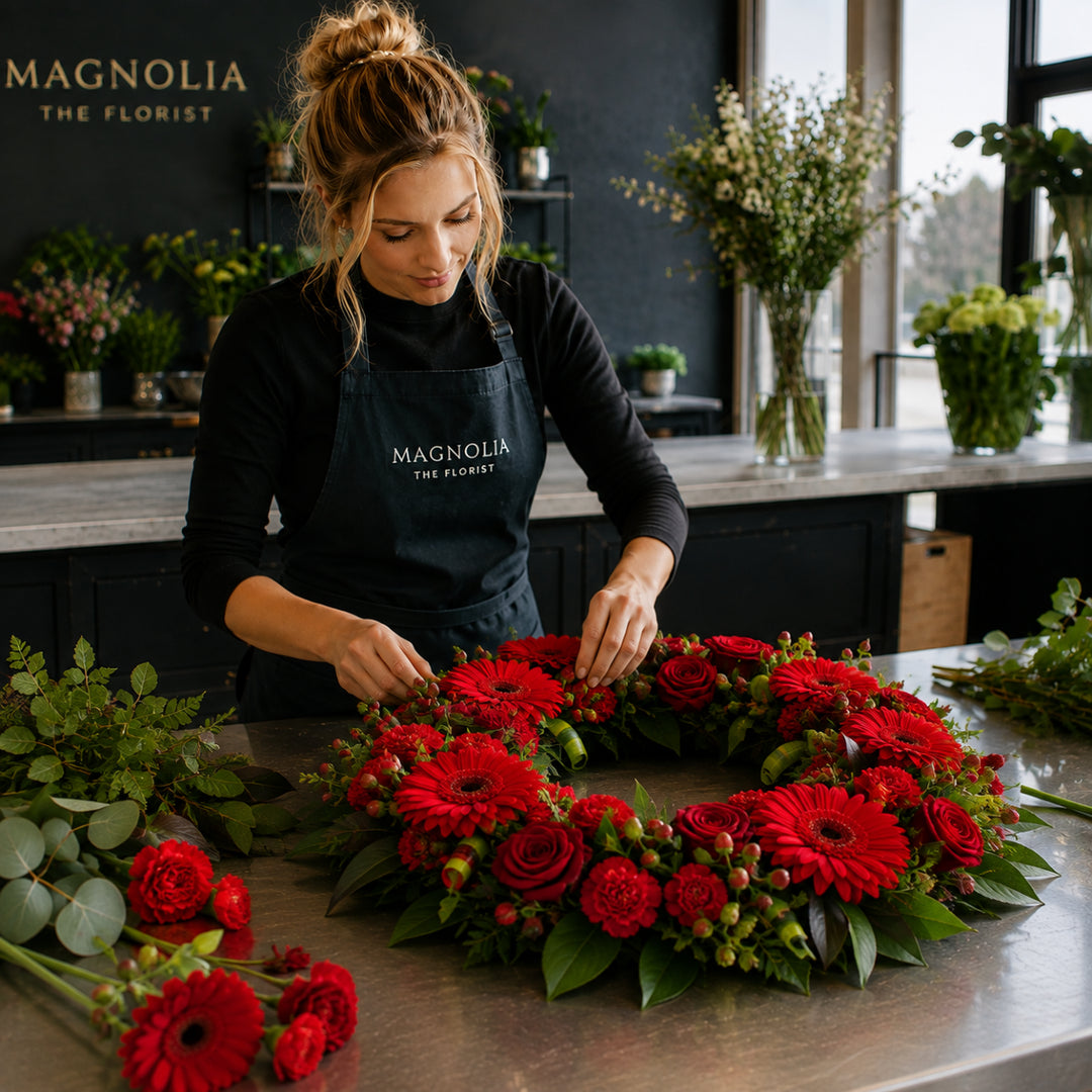 Florist Choice Wreath - Magnolia the Florist Our stunning wreath is made from a selection of beautiful florist-choice flowers, finished with luscious green foliage. We will select the freshest flowers available on the day so, whilst your flowers may look different to the one pictured, they’ll still be just as lovely.. If you cannot find what you want on our site, please call our sales team, we're always happy to assist you. This item requires 1-day notice to order.  1