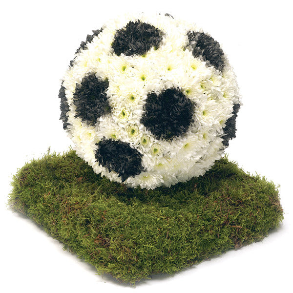 A 3D Footbal funeral tribute, shown on a mossed base, with a white football with black pentagons.