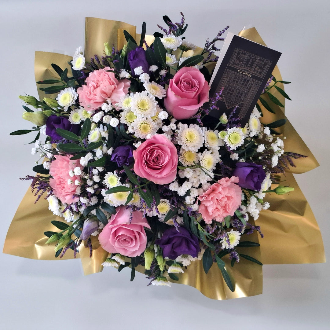 Petite Highgrove Arrangement - Magnolia the Florist Highgrove is a soft, romantic floral arrangement crafted with pink roses, pink carnations, white chrysanthemum, purple lisianthus, limonium, gyp and pistache. Presented in our Magnolia‑branded box and arranged in floral foam for long‑lasting freshness. For scale purposes, our branded box is 15cm (h) x 12cm (w) x 12cm (d), giving an overall size of approximately 25cm (h) x 18cm (w).  2
