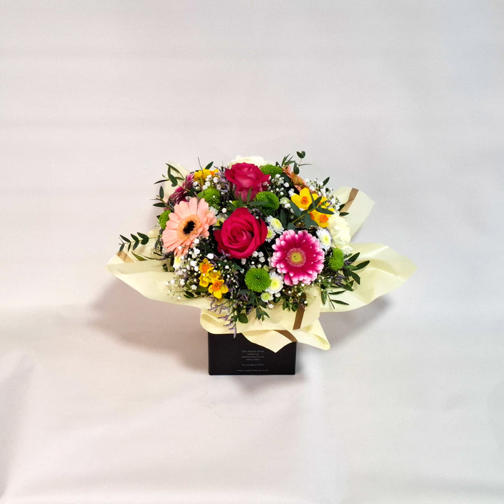 Bouquet of flowers in a box on a light gray background