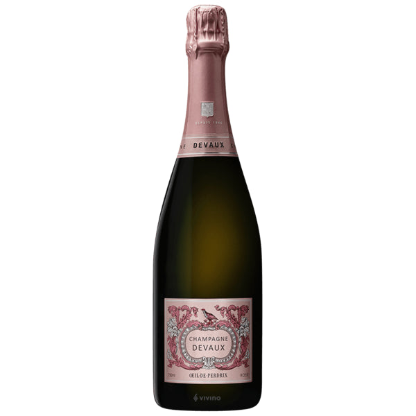 A bottle of rose sparkling champagne with a dark green glass body, a dusty pink foil top, and a pink label with ornate detailing, set against a plain white background.