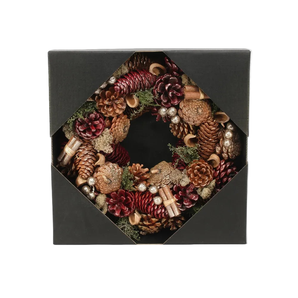 Decorative wreath with pinecones and berries in a black box