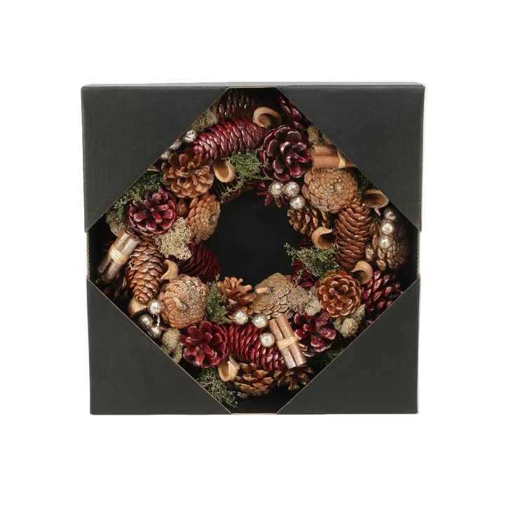 Decorative wreath with pinecones and berries in a black box