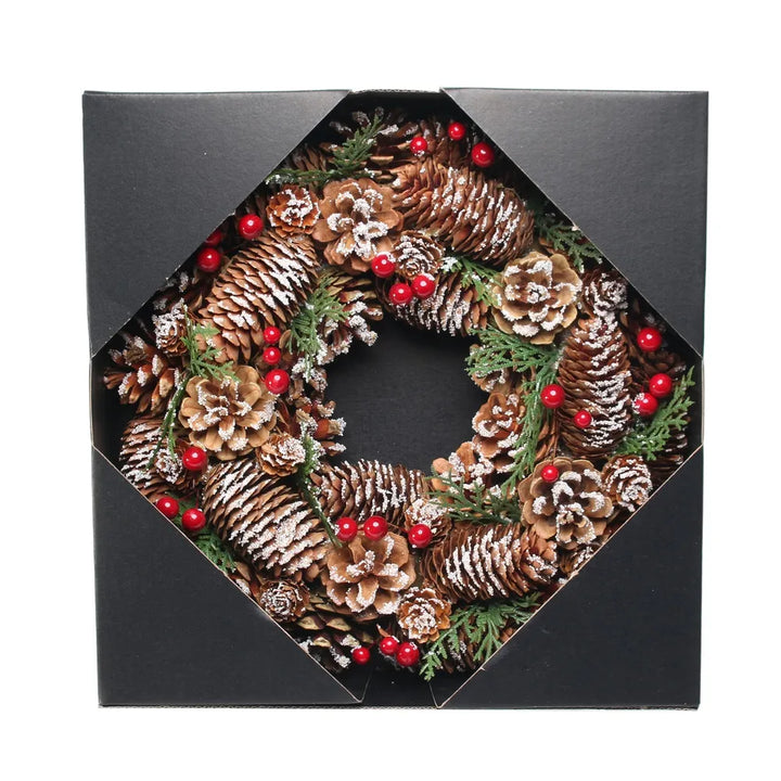 Decorative wreath with pinecones and berries in a black box
